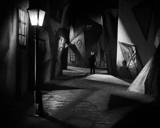 Night street with distorted, angular buildings, deep shadows, and one shadowy figure under harsh lighting in a tense, surreal atmosphere.